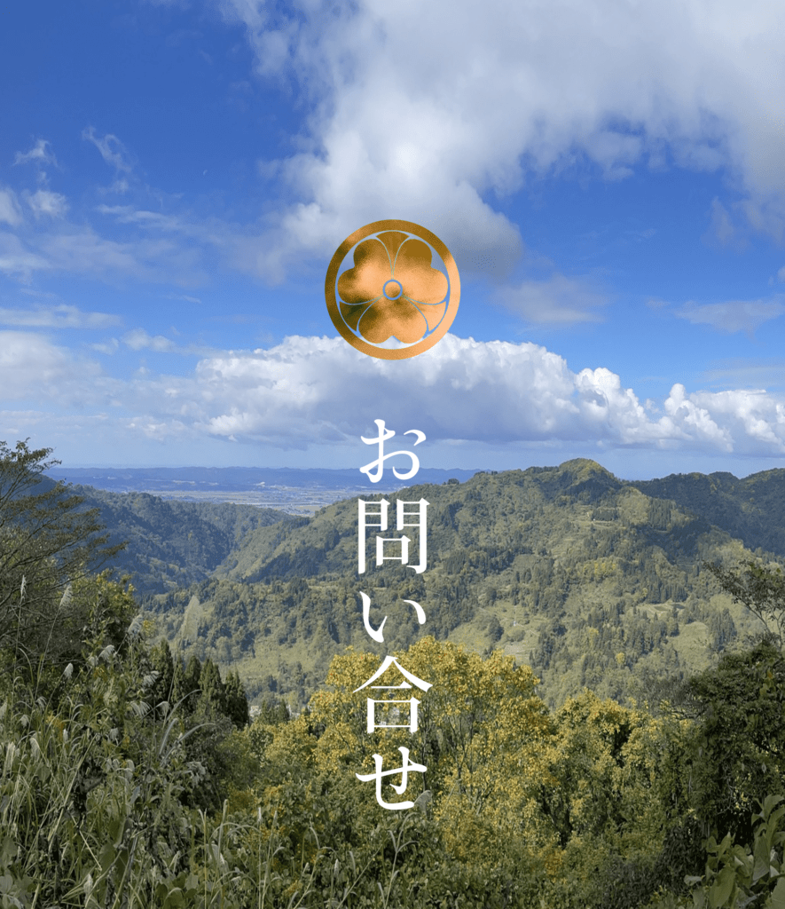 晴天のもとの蓬平地区の山並みの風景をバックにした、慶學寺の丸に劔カタバミの寺門と、お問い合わせページへのリンクバナーです。