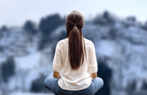 春になっても雪深い残雪の残る山並みを借景に坐禅を組まれる女性