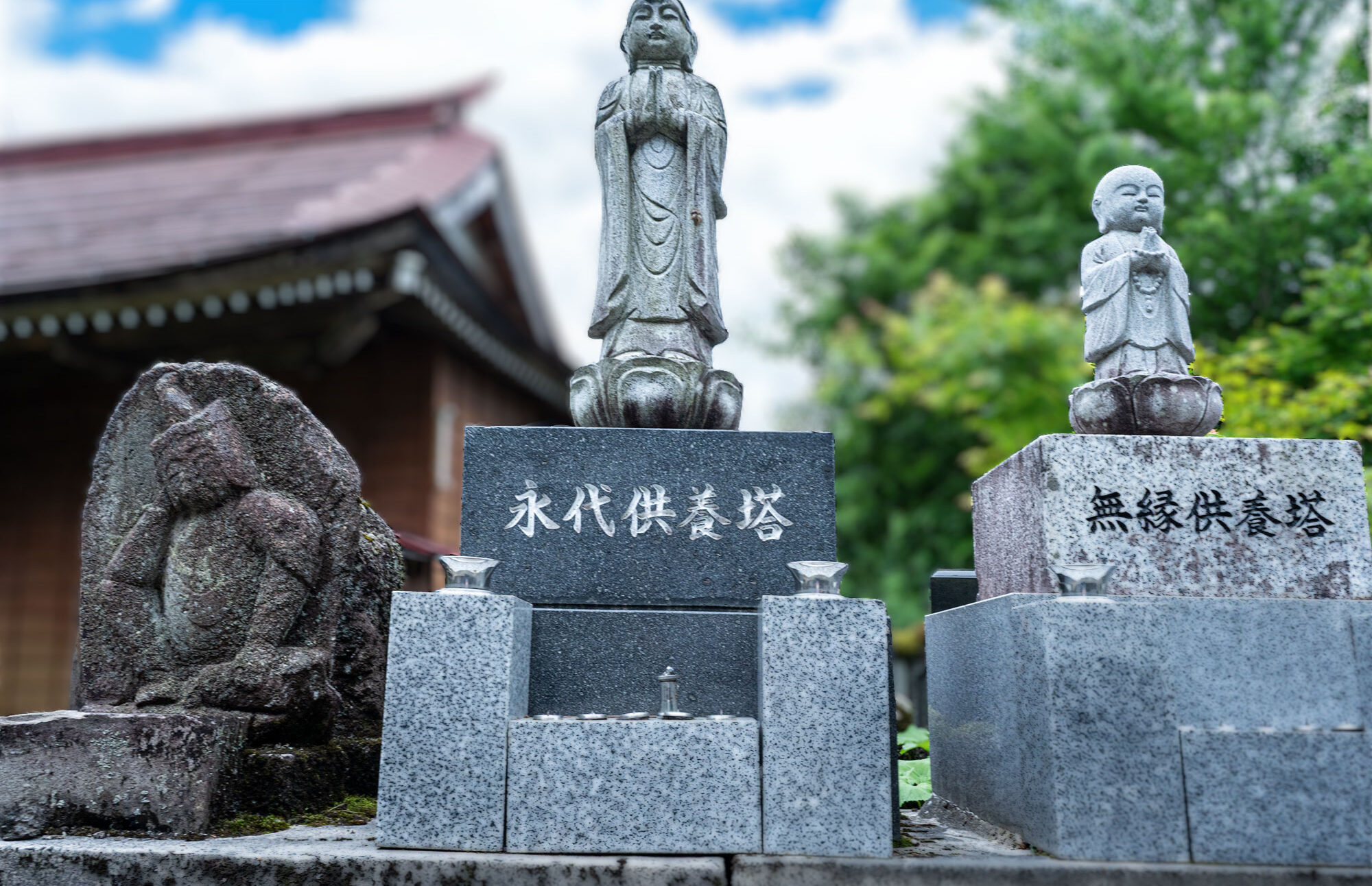 青空のもと慶學寺境内にある永代供養墓および無縁供養墓