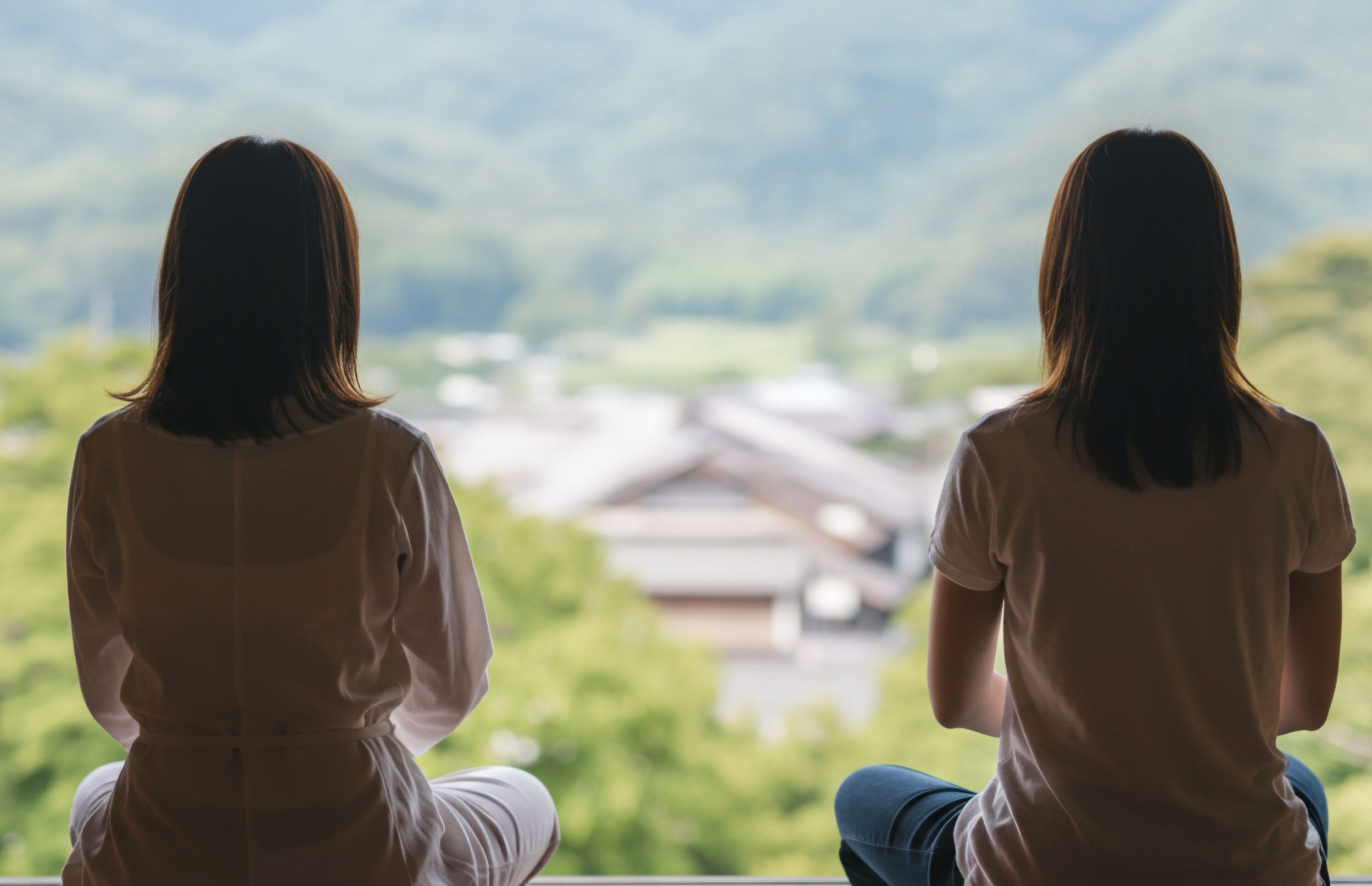 里山の借景を望みながら坐禅を組む２人の女性