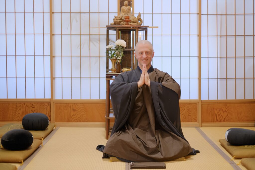慶覺寺の坐禅堂で合掌する住職ガーヴィー春龍