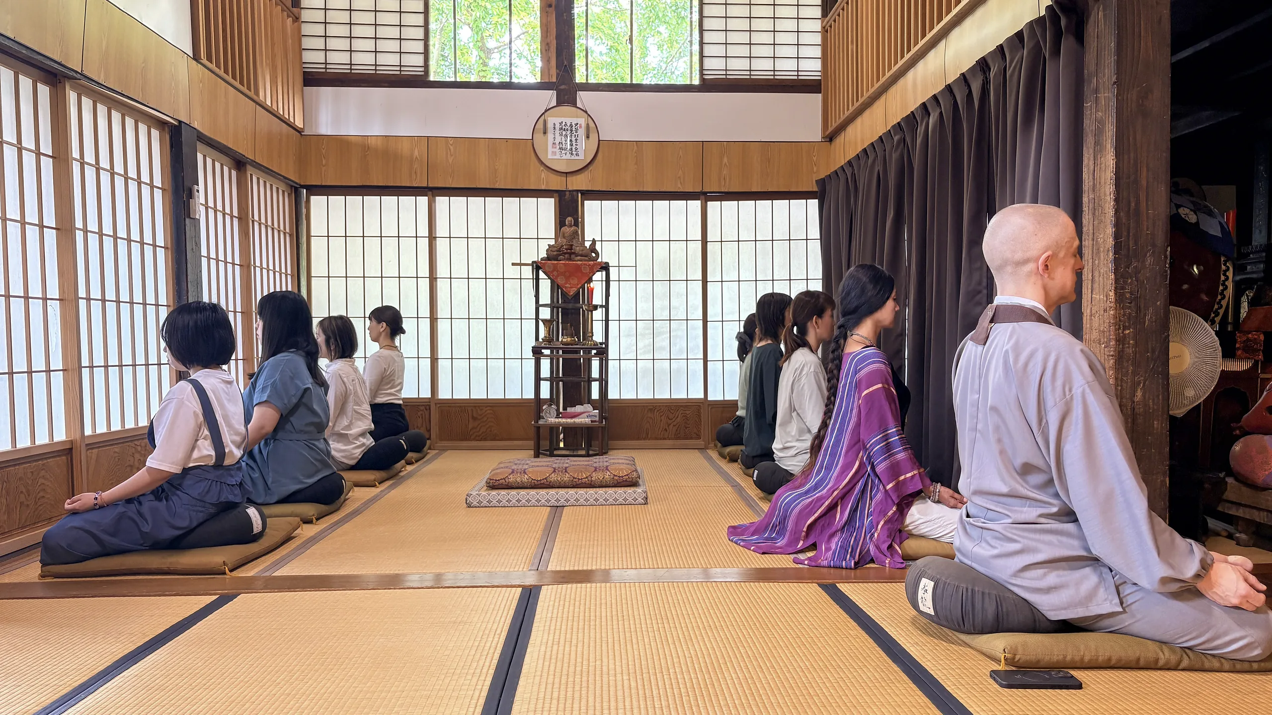 慶覺寺の本堂で、住職とともに坐禅する参加者