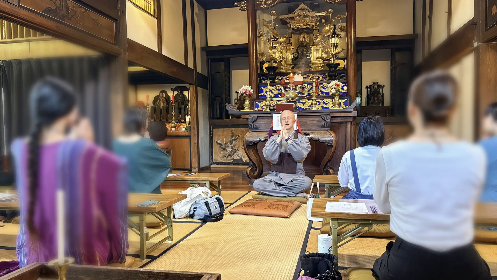 慶覺寺の本堂で、参加者に向かって合掌する春龍住職