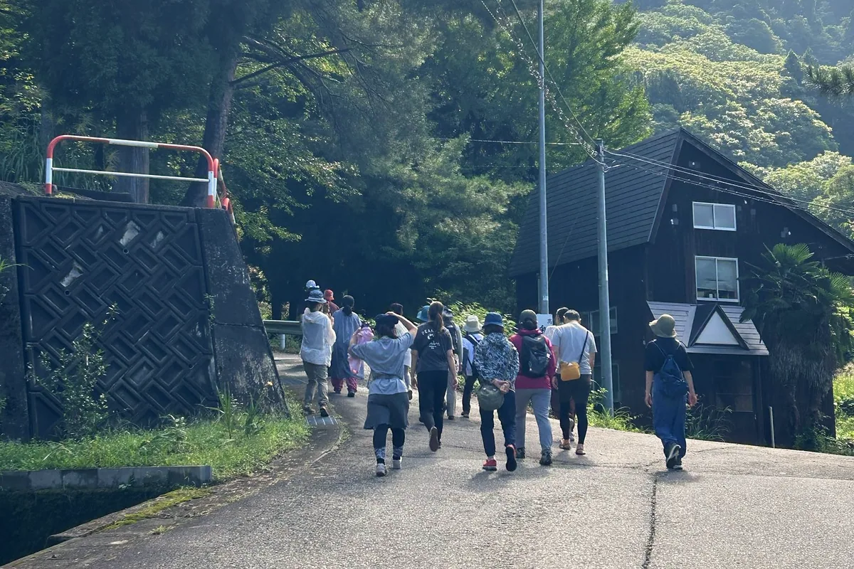木々に囲まれた道を歩いて慶覺寺へ向かう参加者