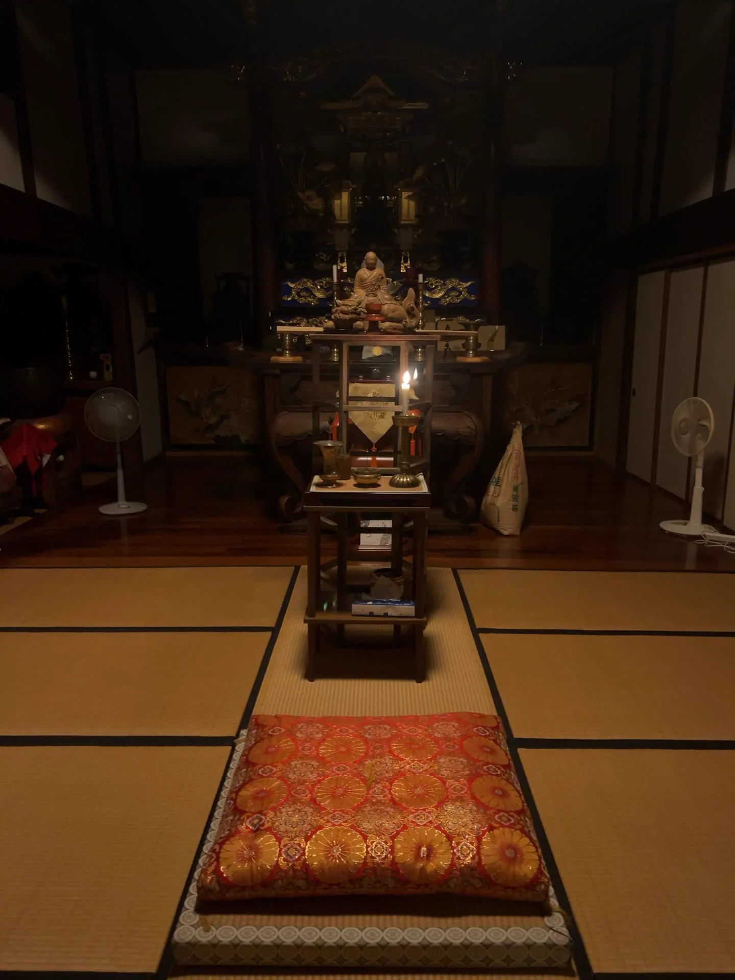 灯りを落とした慶覺寺の本堂と、静かに灯る燭台