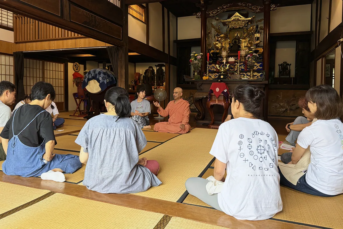 慶覺寺の本堂で輪になって話を聞く参加者
