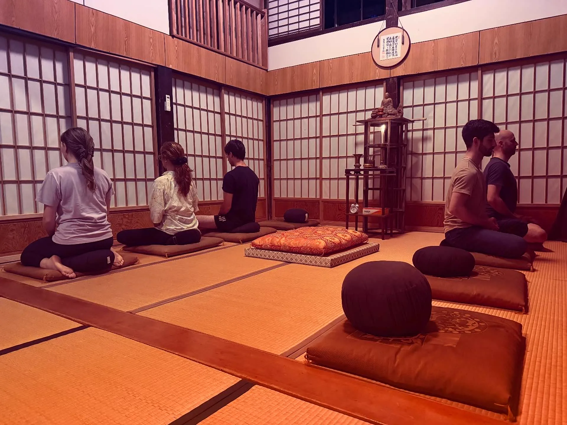 慶覺寺の坐禅堂で坐る少人数の参加者